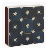 A square box of luxury matches with a dark navy blue cover patterned with cream starbursts and gold text, shown on a clean white background.